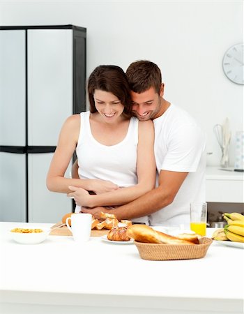 Happy couple hugging while preparing their breakfast together in the kitchen Stock Photo - Budget Royalty-Free & Subscription, Code: 400-04281615