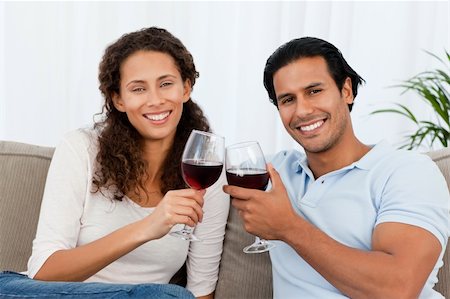 simsearch:400-04663577,k - Portrait of a couple clinking glasses of red wine on the sofa at home Stock Photo - Budget Royalty-Free & Subscription, Code: 400-04281622