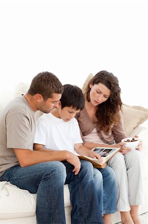 simsearch:400-04151970,k - Adorable family looking at a photo album together on the sofa at home Fotografie stock - Microstock e Abbonamento, Codice: 400-04281637