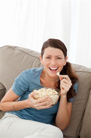 simsearch:400-04268918,k - Portrait of a happy woman eating pop corn while watching television at home Stockbilder - Microstock & Abonnement, Bildnummer: 400-04281650