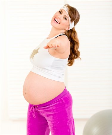 Smiling beautiful pregnant woman doing fitness exercises at living room Stock Photo - Budget Royalty-Free & Subscription, Code: 400-04282571