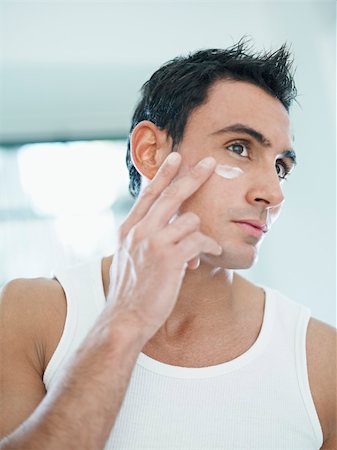 face cream male - young caucasian man applying eye cream on face. Vertical shape, front view, waist up Stock Photo - Budget Royalty-Free & Subscription, Code: 400-04282846