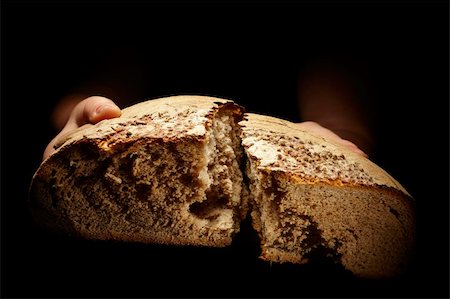 simsearch:400-05701644,k - female hands dividing a brown loaf of bread isolated on black Stock Photo - Budget Royalty-Free & Subscription, Code: 400-04283305