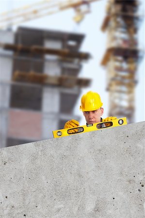 simsearch:400-07304331,k - Worker with level on construction site, empty grey area great for text or design Stock Photo - Budget Royalty-Free & Subscription, Code: 400-04283356