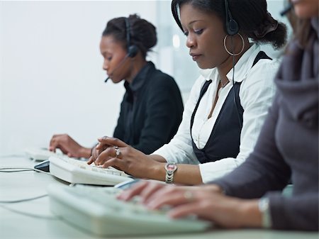 multiethnic group of female customer service representatives talking on the phone and typing on computer keyboard. Horizontal shape, side view, copy space Stock Photo - Budget Royalty-Free & Subscription, Code: 400-04283661