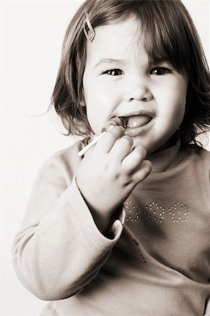 simsearch:400-07568470,k - Toddler girl with chubby cheeks eating a sticky lollipop Stockbilder - Microstock & Abonnement, Bildnummer: 400-04283891