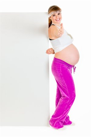 simsearch:400-07892390,k - Smiling beautiful pregnant woman holding blank billboard and showing thumbs up gesture isolated on white Photographie de stock - Aubaine LD & Abonnement, Code: 400-04294345