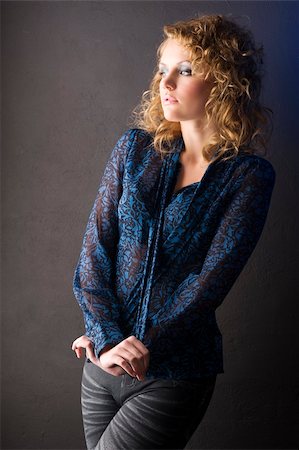simsearch:400-08116534,k - fashion shot of beautiful blond woman with curly hair wearing a blue shirt on black background Stock Photo - Budget Royalty-Free & Subscription, Code: 400-04295414