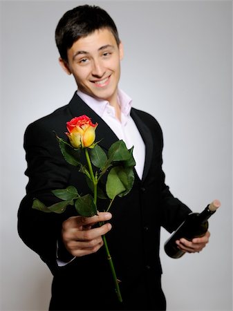 rose bottle - Handsome romantic young man holding rose flower and vine bottle  prepared for a date. gray background Stock Photo - Budget Royalty-Free & Subscription, Code: 400-04296022