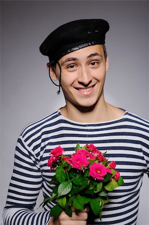 simsearch:400-05294518,k - Funny emotional romantic sailor man holding rose flowers prepared for a date Fotografie stock - Microstock e Abbonamento, Codice: 400-04296035