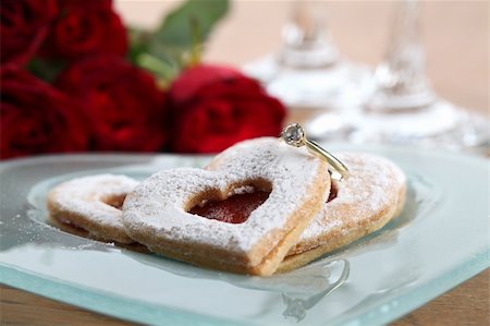red flowers in stone images - Gold engagement ring with shortbread hearts on a plate, red roses and wine glasses. Shallow dof Stock Photo - Budget Royalty-Free & Subscription, Code: 400-04296309
