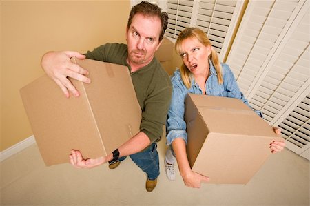 Obviously Exhausted Couple Holding Moving Boxes in Empty Room. Stock Photo - Budget Royalty-Free & Subscription, Code: 400-04296389