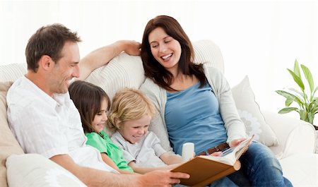 family photos in album - Happy parents looking at a photo album with their children on the sofa Stock Photo - Budget Royalty-Free & Subscription, Code: 400-04296600