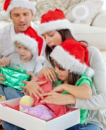 father christmas family portrait - Cute little girl opening a christmas present with her mother in the living room Photographie de stock - Aubaine LD & Abonnement, Code: 400-04296616