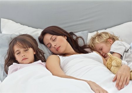 Adorable children sleeping with their mother on her bed at home Stock Photo - Budget Royalty-Free & Subscription, Code: 400-04296634