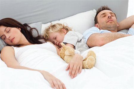 Cute little boy slieeping with her parent in the morning at home Stock Photo - Budget Royalty-Free & Subscription, Code: 400-04296635