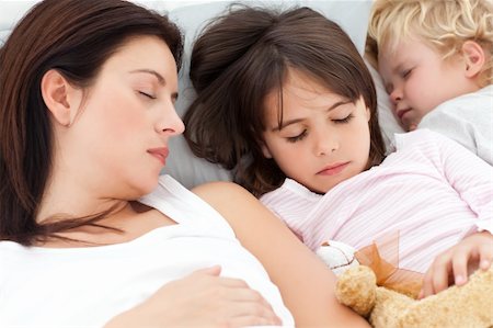 simsearch:400-06452404,k - Adorable brother and sister sleeping with their mother in her bed at home Photographie de stock - Aubaine LD & Abonnement, Code: 400-04296637