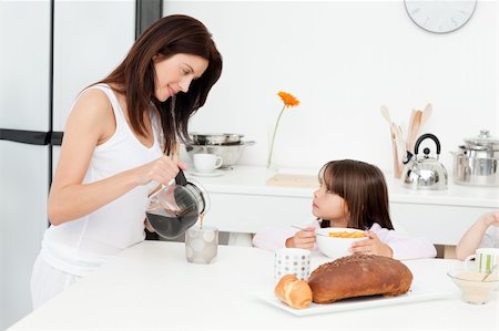 Pretty mom pouring coffee while her children having breakfast in the kitchen Stock Photo - Budget Royalty-Free & Subscription, Code: 400-04296666