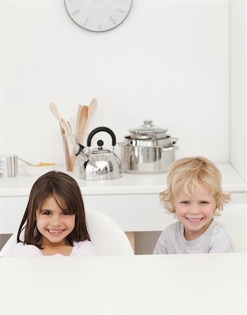 Happy brother and sister waiting their breakfast sitting in the kitchen Stock Photo - Budget Royalty-Free & Subscription, Code: 400-04296685