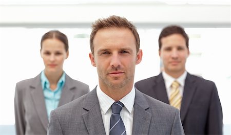 simsearch:400-04287075,k - Serious manager posing in front of his two employees in the office Fotografie stock - Microstock e Abbonamento, Codice: 400-04296708