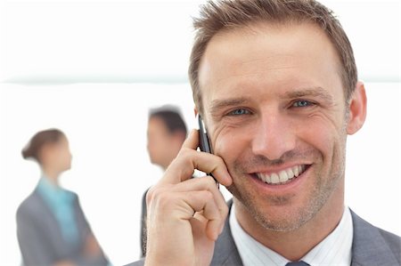 simsearch:400-04287075,k - Portrait of a businessman on the phone during a meeting with his team Fotografie stock - Microstock e Abbonamento, Codice: 400-04296718