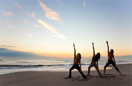 Three young women in a warrior position practicing yoga on a beach at sunrise or sunset Stock Photo - Budget Royalty-Free & Subscription, Code: 400-04296858