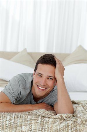 Portrait of a cheerful man lying on his bed at home Stock Photo - Budget Royalty-Free & Subscription, Code: 400-04296894