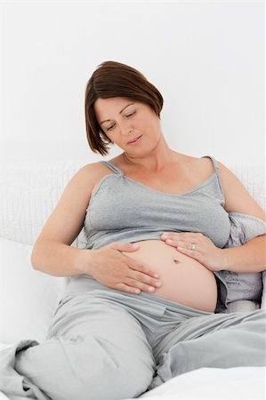 simsearch:400-05918412,k - Pregnant woman cuddling her belly at home Foto de stock - Royalty-Free Super Valor e Assinatura, Número: 400-04297005