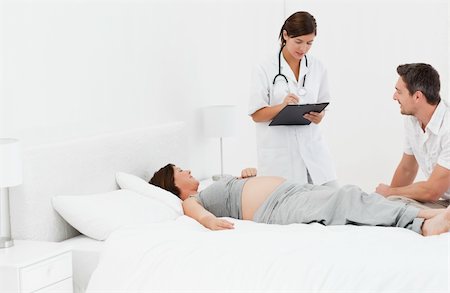 simsearch:400-04266840,k - Pregnant woman with her husband and a nurse Photographie de stock - Aubaine LD & Abonnement, Code: 400-04297025