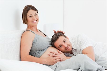 simsearch:400-04266840,k - Husband listening to his wife's belly at home Photographie de stock - Aubaine LD & Abonnement, Code: 400-04297046