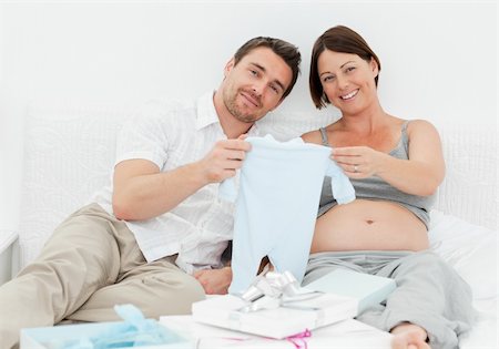 simsearch:400-04266844,k - Young futur parents with chlidrens clothes at home Stock Photo - Budget Royalty-Free & Subscription, Code: 400-04297056