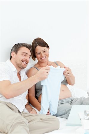 simsearch:400-04266844,k - Young futur parents with chlidrens clothes at home Stock Photo - Budget Royalty-Free & Subscription, Code: 400-04297336