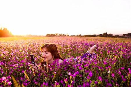 Beautiful young woman lying on the nature and talking at cellphone Stock Photo - Budget Royalty-Free & Subscription, Code: 400-04298039