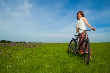 simsearch:400-04201795,k - Happy young woman on a green meadow with a vintage bicycle Fotografie stock - Microstock e Abbonamento, Codice: 400-04298041