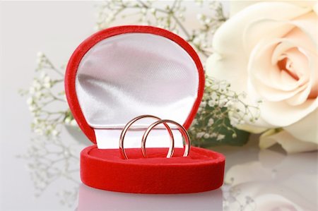 Two gold rings in red box near beautiful creame roses with reflection Foto de stock - Super Valor sin royalties y Suscripción, Código: 400-04298281