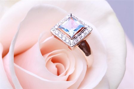 simsearch:400-03937506,k - Gold engagement ring with blue diamond in cream rose Photographie de stock - Aubaine LD & Abonnement, Code: 400-04298339