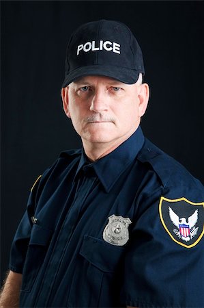 first responder - Portrait of a serious police officer, photographed over a black background. Stock Photo - Budget Royalty-Free & Subscription, Code: 400-04299079