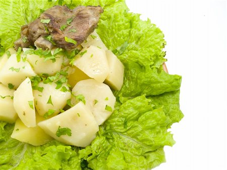 floor of the frame is filled by stewed potatoes which is located on plate with sheet of the green salad Stockbilder - Microstock & Abonnement, Bildnummer: 400-04299284