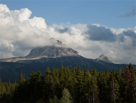 simsearch:614-02391976,k - Big Chief Mountain in Glacier National Park on a day when it is surrounded by a halo of clouds. The mountain is a granite monolith that rises by itself in a corner of the park. Foto de stock - Super Valor sin royalties y Suscripción, Código: 400-04299292