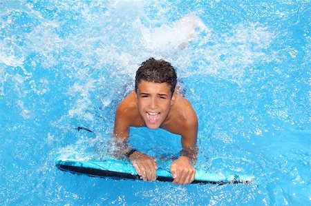 simsearch:400-04124750,k - boy teenager surfboard splashing blue water happy in sea pool Stock Photo - Budget Royalty-Free & Subscription, Code: 400-04299761