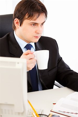 simsearch:400-05900668,k - Thoughtful business man  sitting at office desk  and holding cup of tea in hand Stock Photo - Budget Royalty-Free & Subscription, Code: 400-04299810