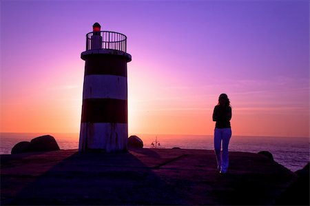 simsearch:400-04515946,k - Beautiful landscape picture of a lighthouse and a woman looking the sunset Foto de stock - Super Valor sin royalties y Suscripción, Código: 400-04290847