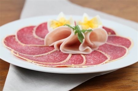 Salami with parmesan crust on a plate with ham and eggs. Shallow dof Stock Photo - Budget Royalty-Free & Subscription, Code: 400-04291995