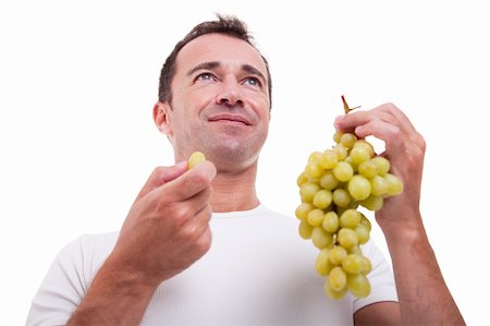 handsome man eating a green grapes, isolated on white background. Studio shot. Stock Photo - Budget Royalty-Free & Subscription, Code: 400-04292029