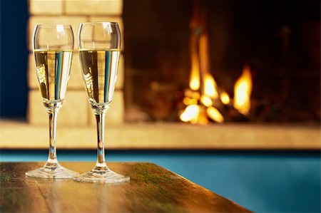 fire romance - closeup of two wine glasses with champagne on table and fireplace in background. Horizontal shape Stock Photo - Budget Royalty-Free & Subscription, Code: 400-04304236