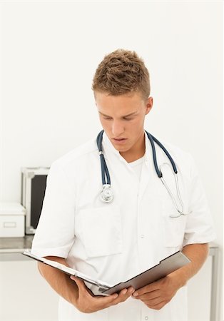 Handsome blond doctor reading results of medical test Stock Photo - Budget Royalty-Free & Subscription, Code: 400-04304417