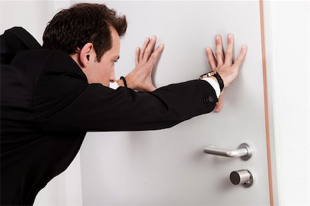 pushing door - Businessman pushing the door to prevent people entering room Stock Photo - Budget Royalty-Free & Subscription, Code: 400-04307265