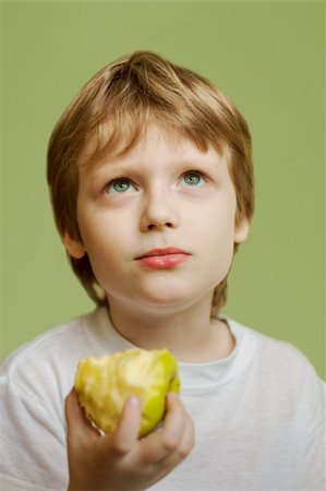 The seven-year blonde child eats an apple. Fotografie stock - Microstock e Abbonamento, Codice: 400-04309642
