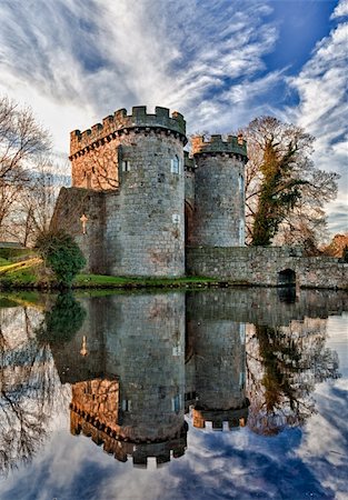 Ancient Whittington Castle in Shropshire, England reflecting in a calm moat round the stone buildings and processed in HDR Stock Photo - Budget Royalty-Free & Subscription, Code: 400-04300287