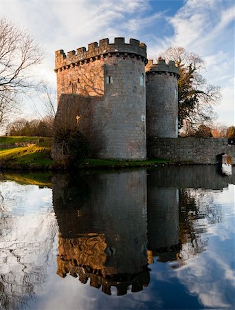 Ancient Whittington Castle in Shropshire, England reflecting in a calm moat round the stone buildings Stock Photo - Budget Royalty-Free & Subscription, Code: 400-04300375
